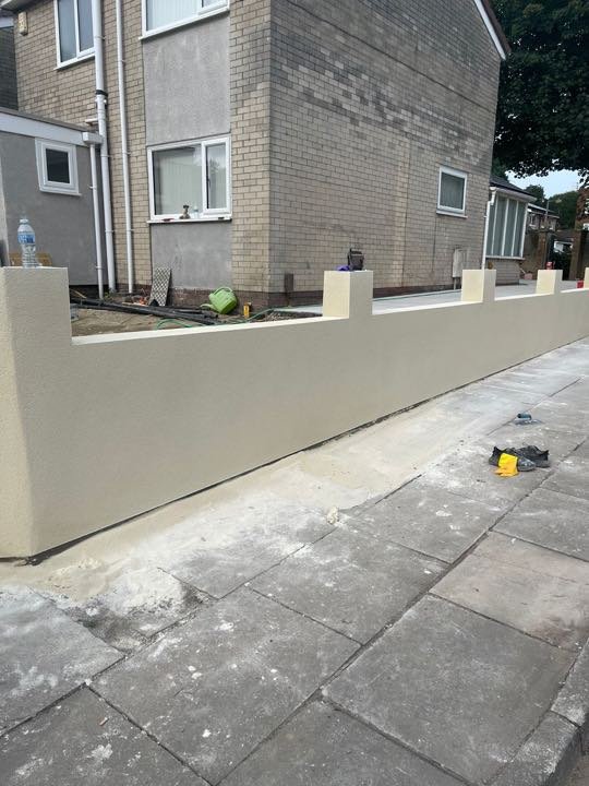 Cream rendered front garden wall with piers built by North West Landscapes, still under construction with materials on the ground