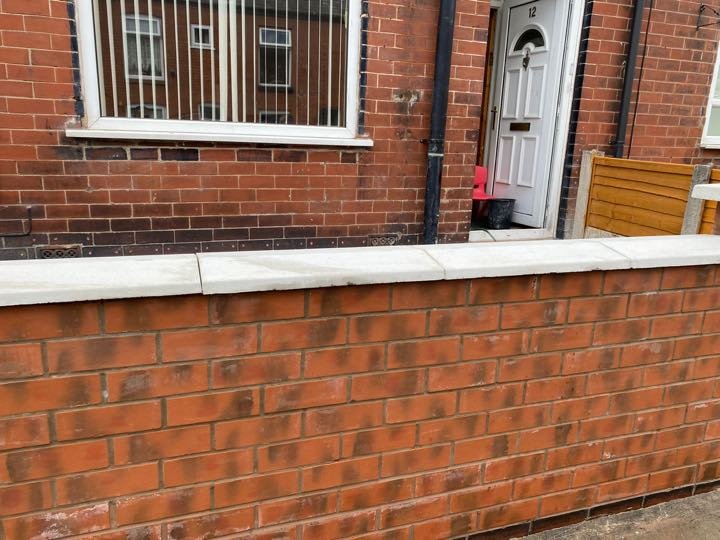 New red brick front garden boundary wall with smooth concrete coping stones built by North West Landscapes