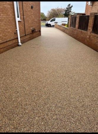 Golden resin bound driveway laid down the side of a house by North West Landscapes