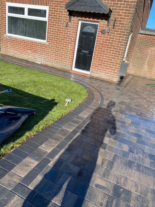 Brindle tumbled block paving driveway with curved border and lawn edge by North West Landscapes