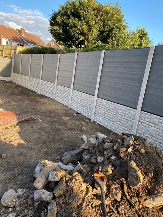 Grey composite panel fencing with stone-effect gravel boards installed by North West Landscapes along a rear garden boundary
