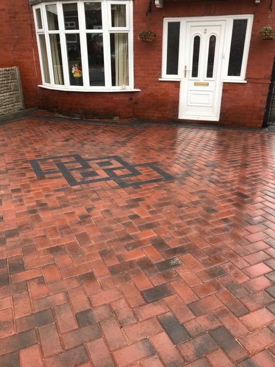 Red block paving driveway with charcoal Greek key feature by North West Landscapes