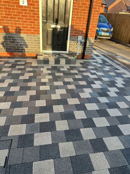 Block paving driveway laid in a charcoal and silver checkerboard pattern by North West Landscapes
