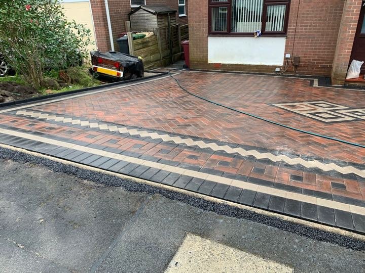 Brindle block paving driveway with cream soldier course, charcoal border and Greek key detail by North West Landscapes